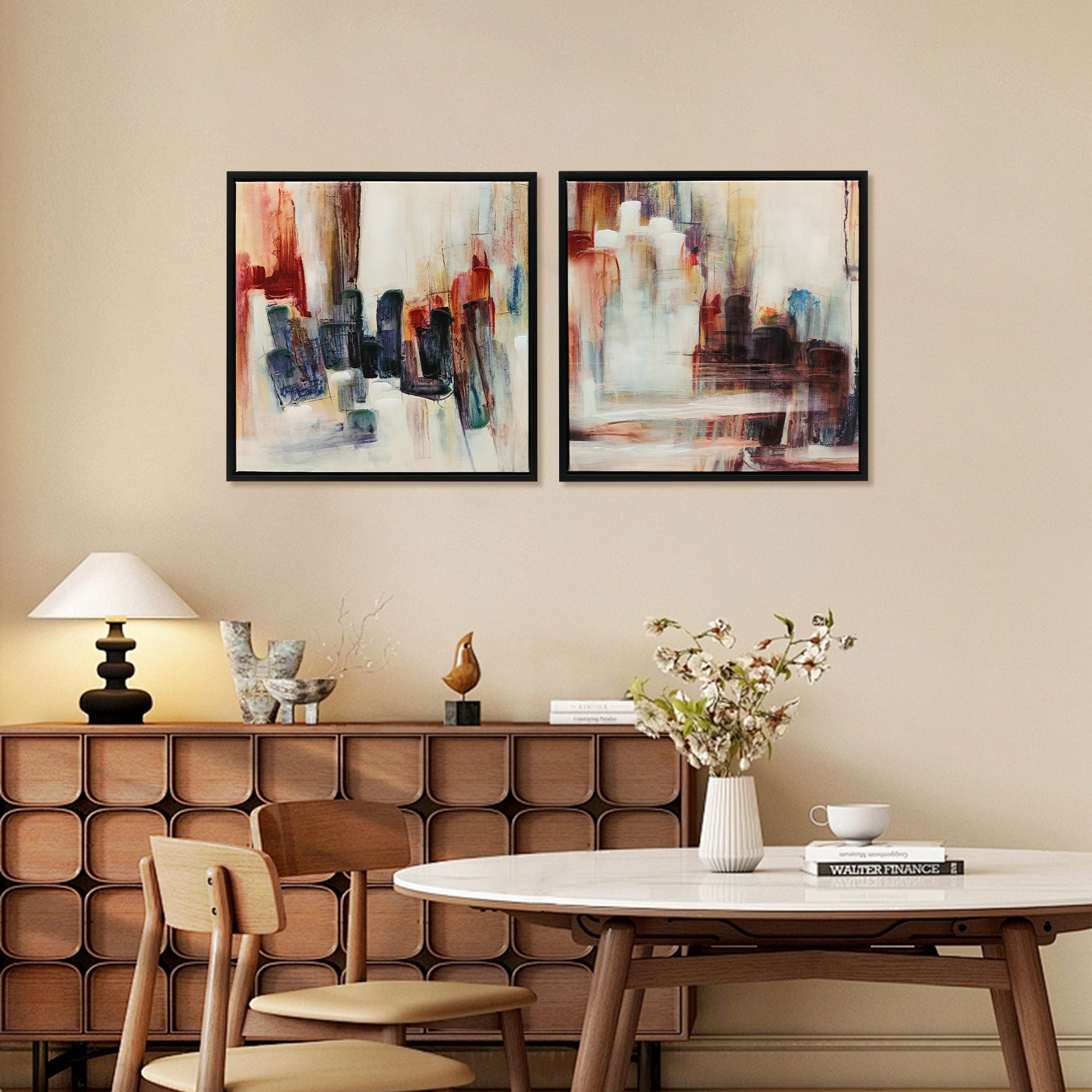 Dos pinturas abstractas enmarcadas cuelgan sobre un aparador en un comedor moderno.