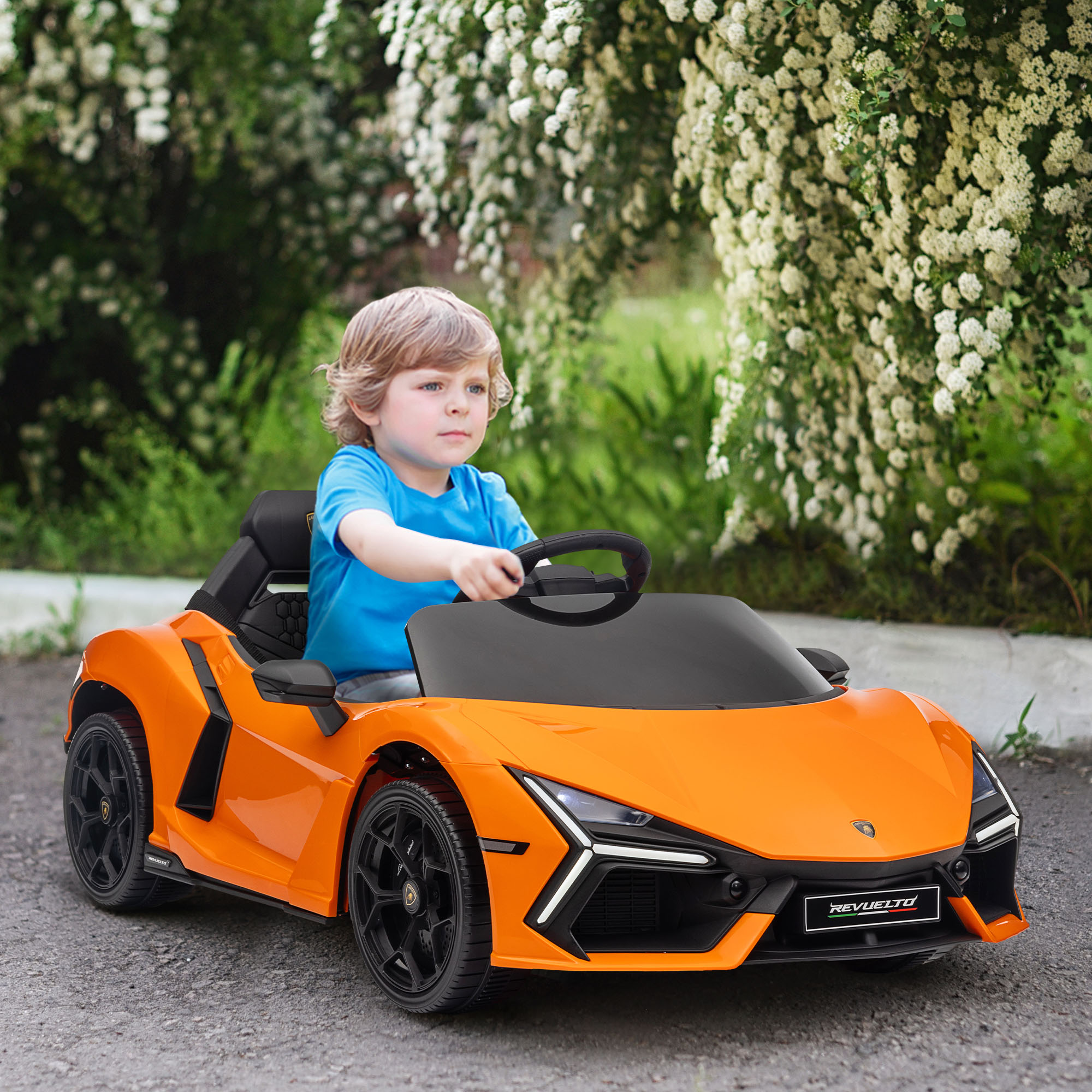 Un bambino con la maglietta blu guida un'auto giocattolo arancione su una strada.