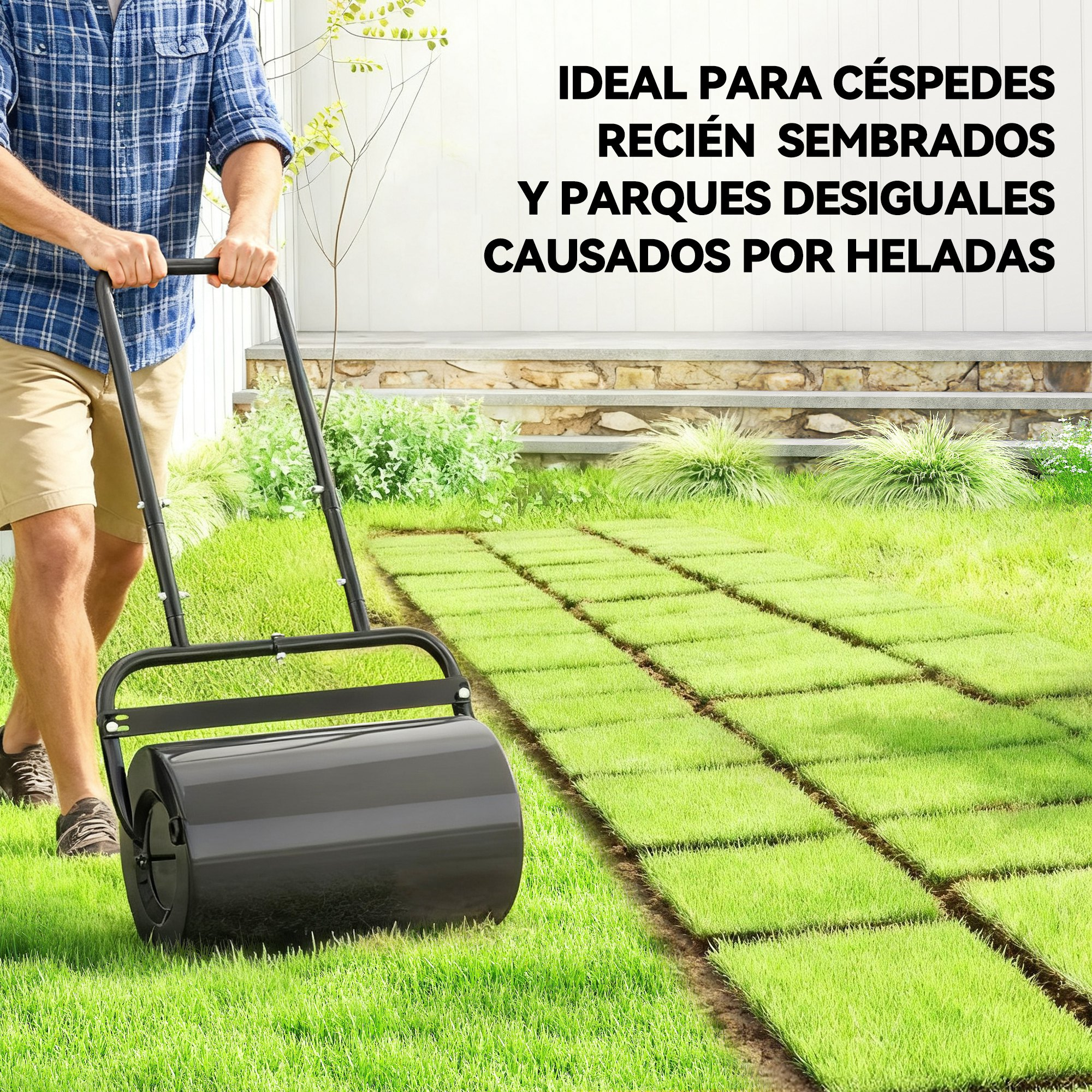 Un hombre pasa un pesado rodillo de césped negro sobre césped recién instalado.