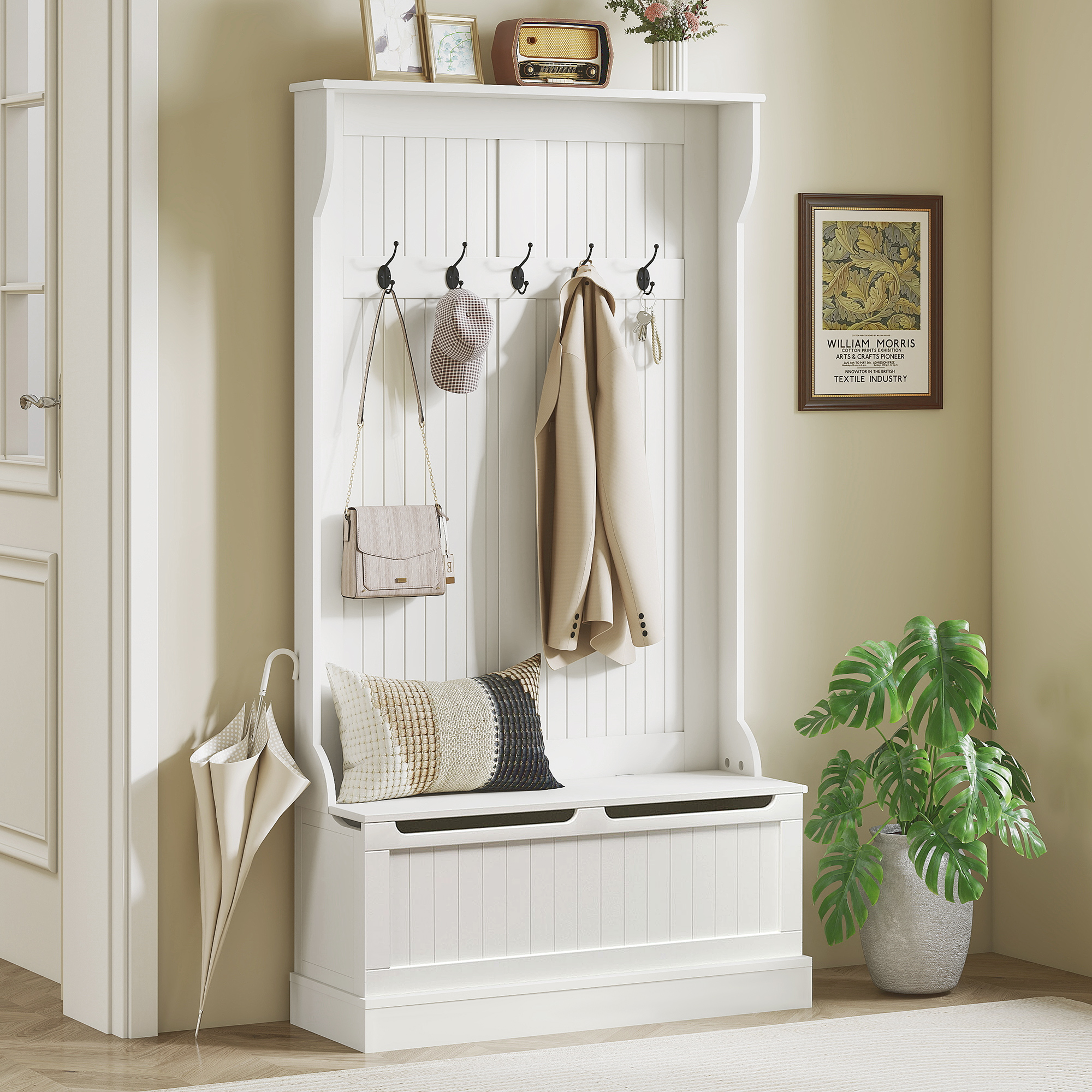 Mueble recibidor blanco con ganchos, cojín, bolso colgante, abrigo, paraguas y planta.