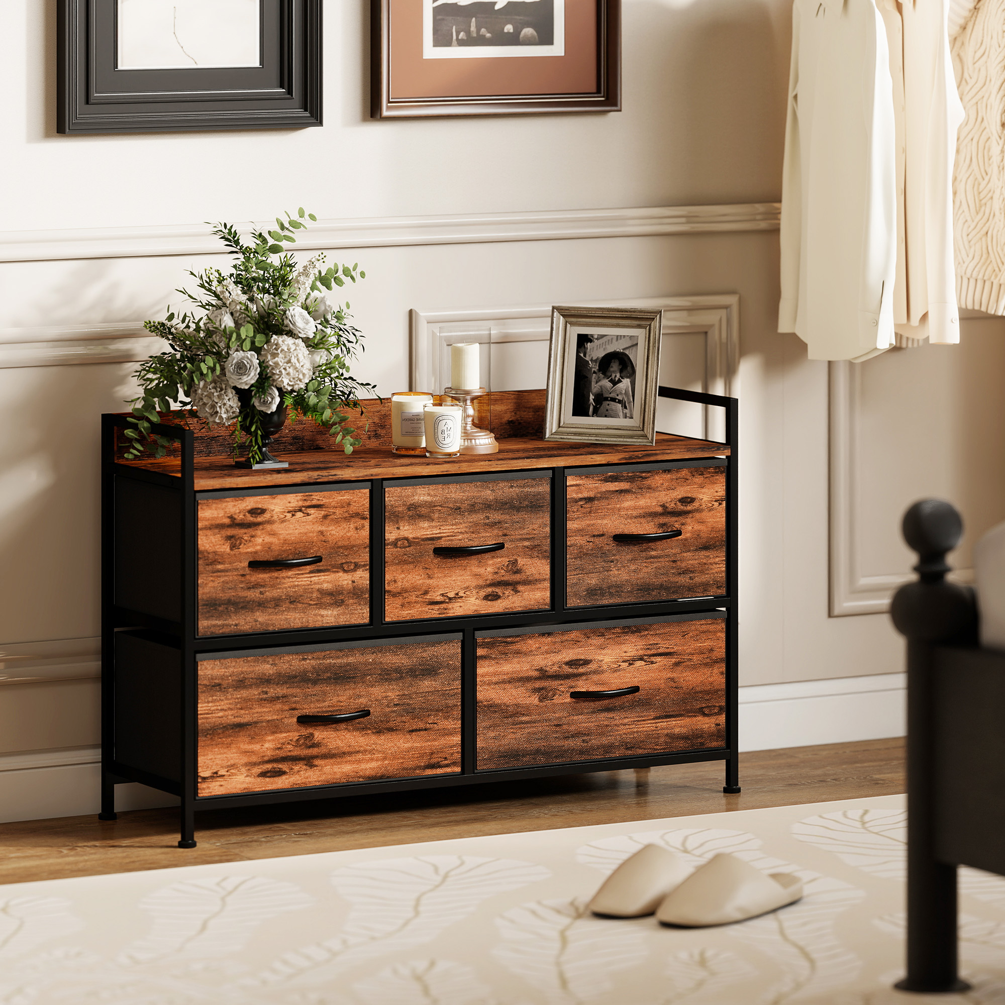Mueble de madera rústico con cinco cajones, marco de metal negro, flores, velas y un marco de fotos.