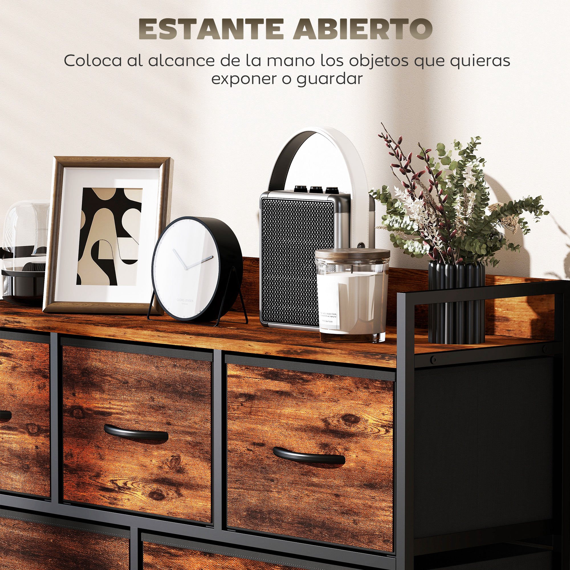 Mueble de madera y metal con cajones, decorado con reloj, cuadro, vela y planta.