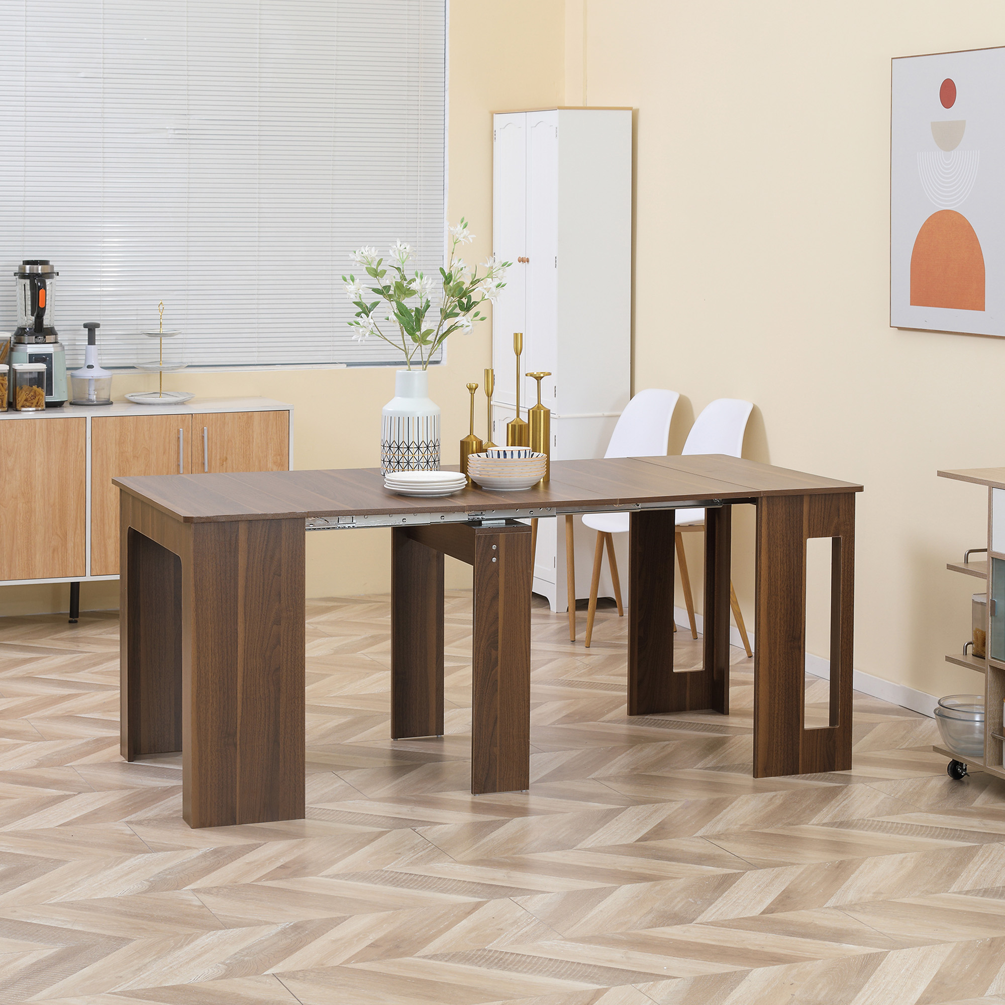 Una mesa de comedor extensible de madera se encuentra en el centro de un suelo de parquet, con florero y cuencos.