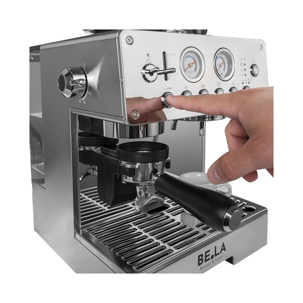 Une main appuie sur un bouton d'une machine à espresso argentée brillante.