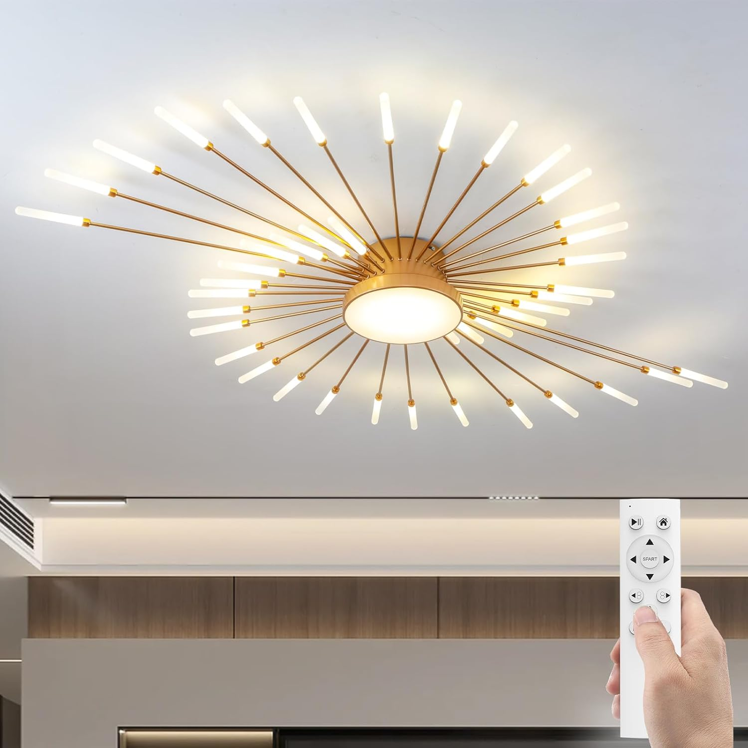 Moderne goldene Deckenleuchte mit strahlenden Lichtern, bedient per Fernbedienung in einer Hand.