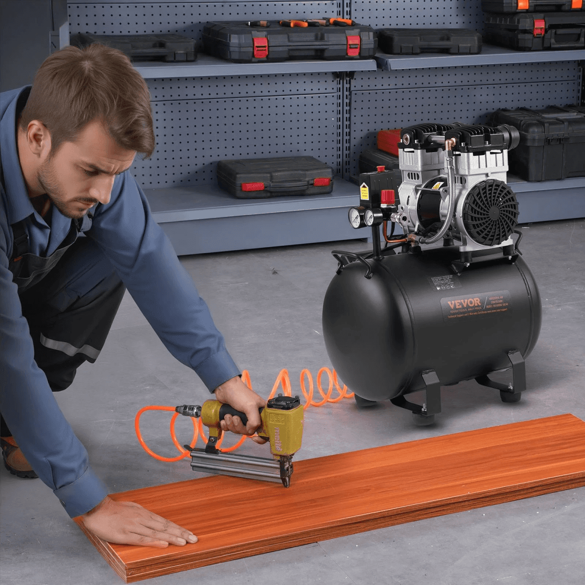 Un artesano usa una clavadora conectada a un compresor negro en madera.
