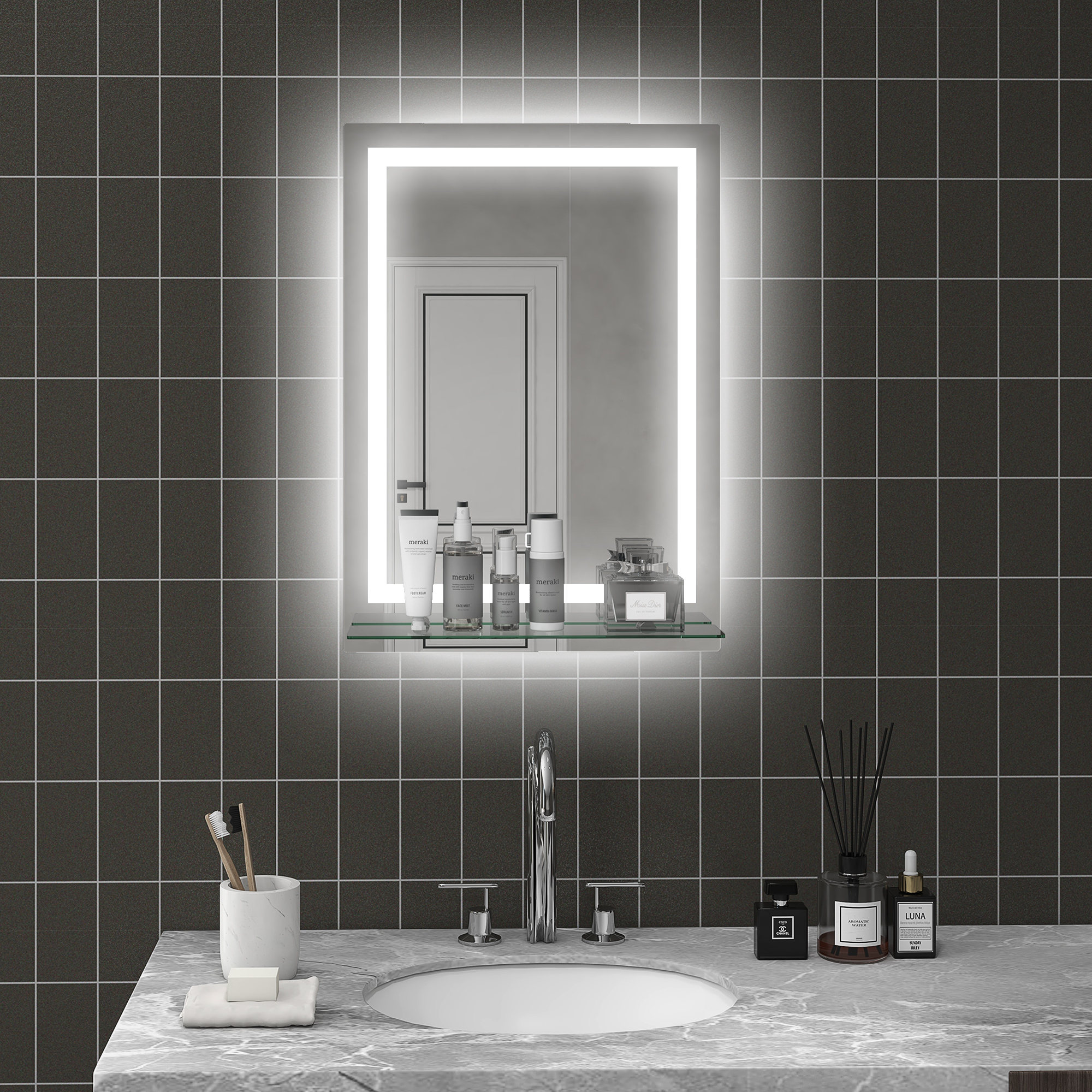 Espejo de baño iluminado sobre lavabo de mármol con azulejos grises.