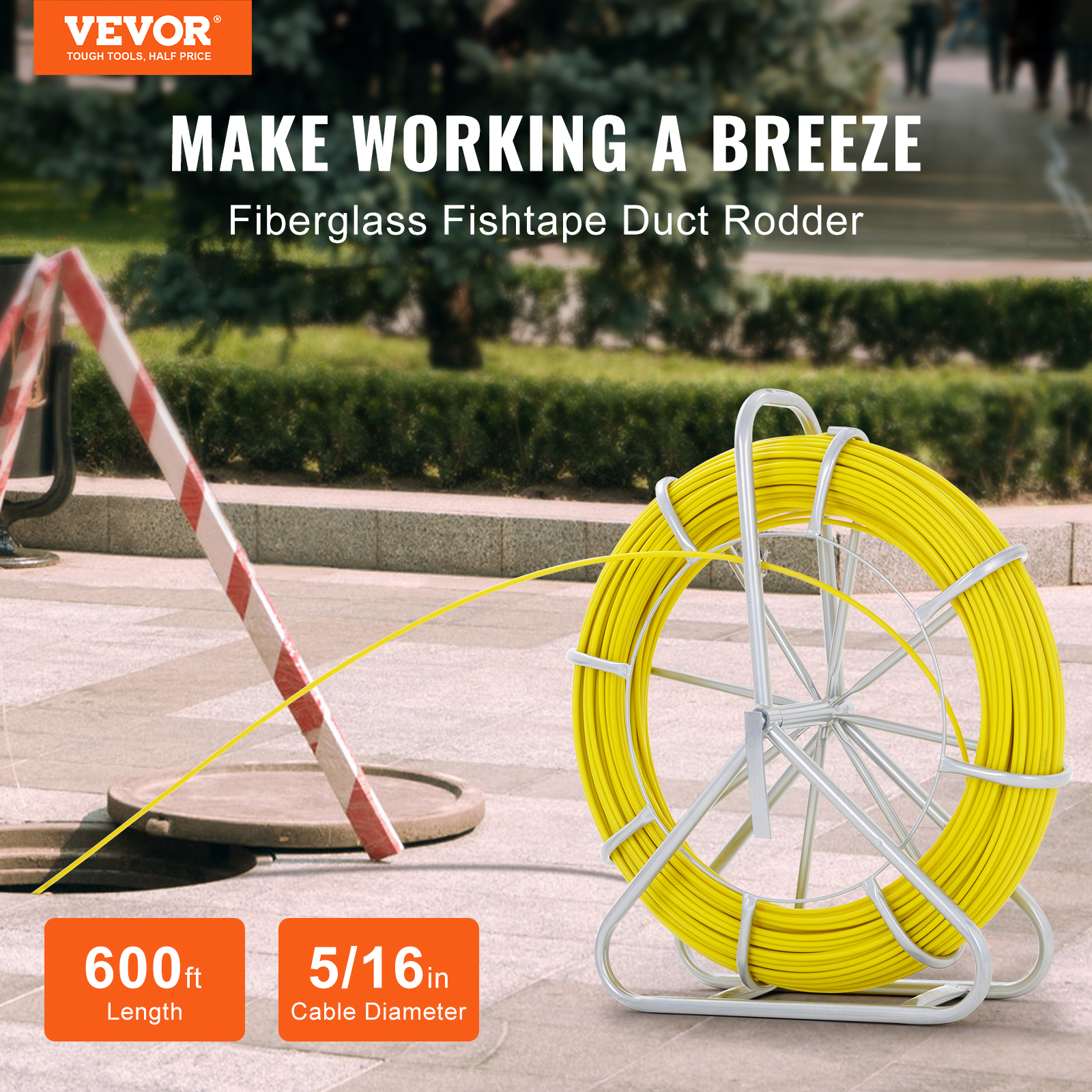 Un cable de fibra de vidrio amarillo en una bobina metálica plateada al aire libre cerca de una alcantarilla abierta.