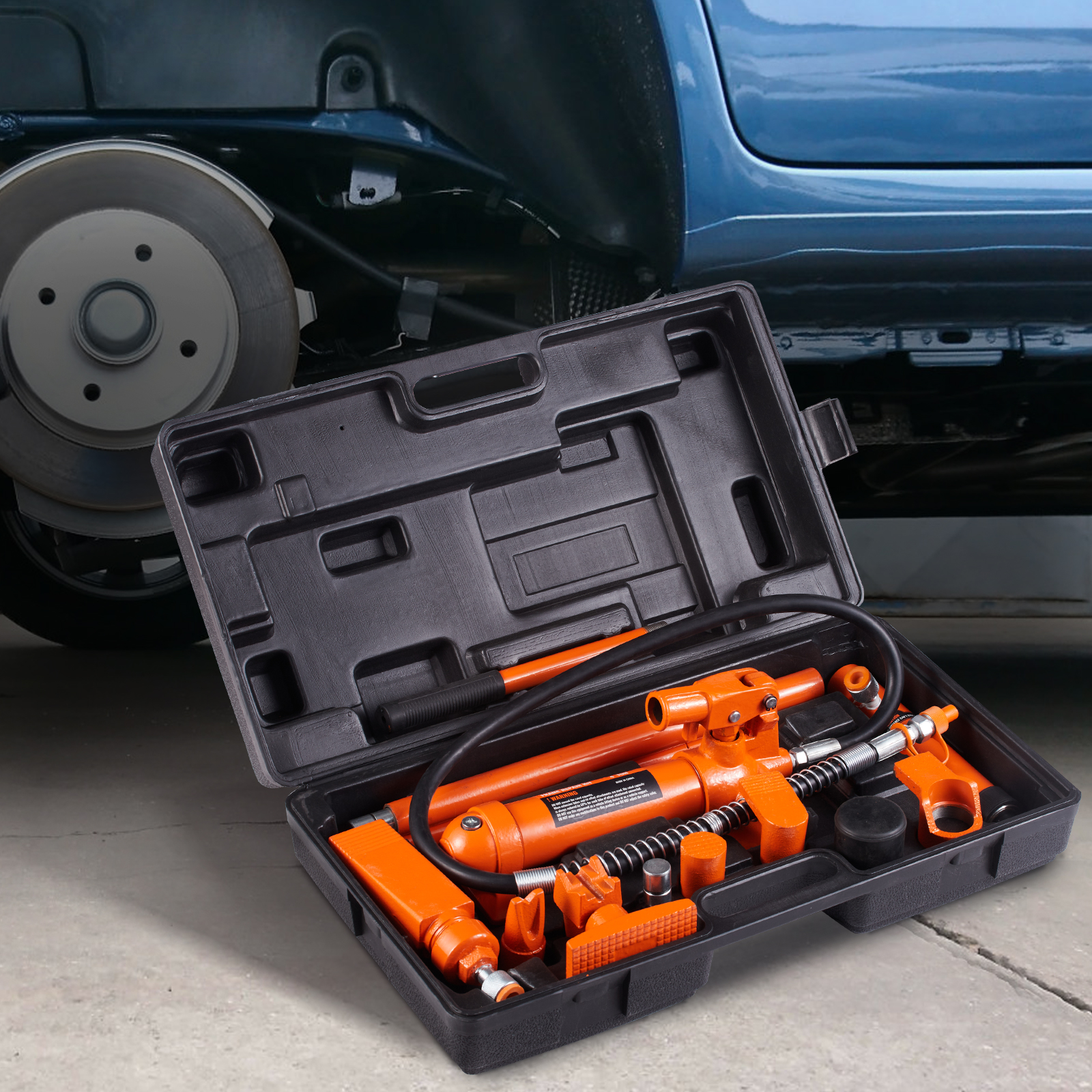 Un estuche negro abierto con un kit de gato hidráulico naranja se coloca frente a un coche azul.