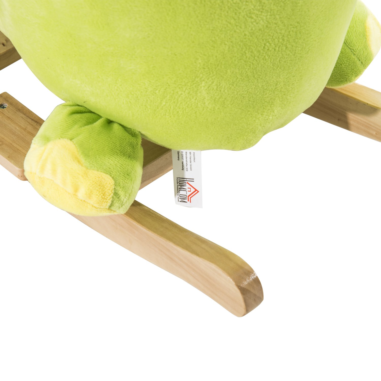 Juguete balancín de peluche verde sobre rieles de madera.