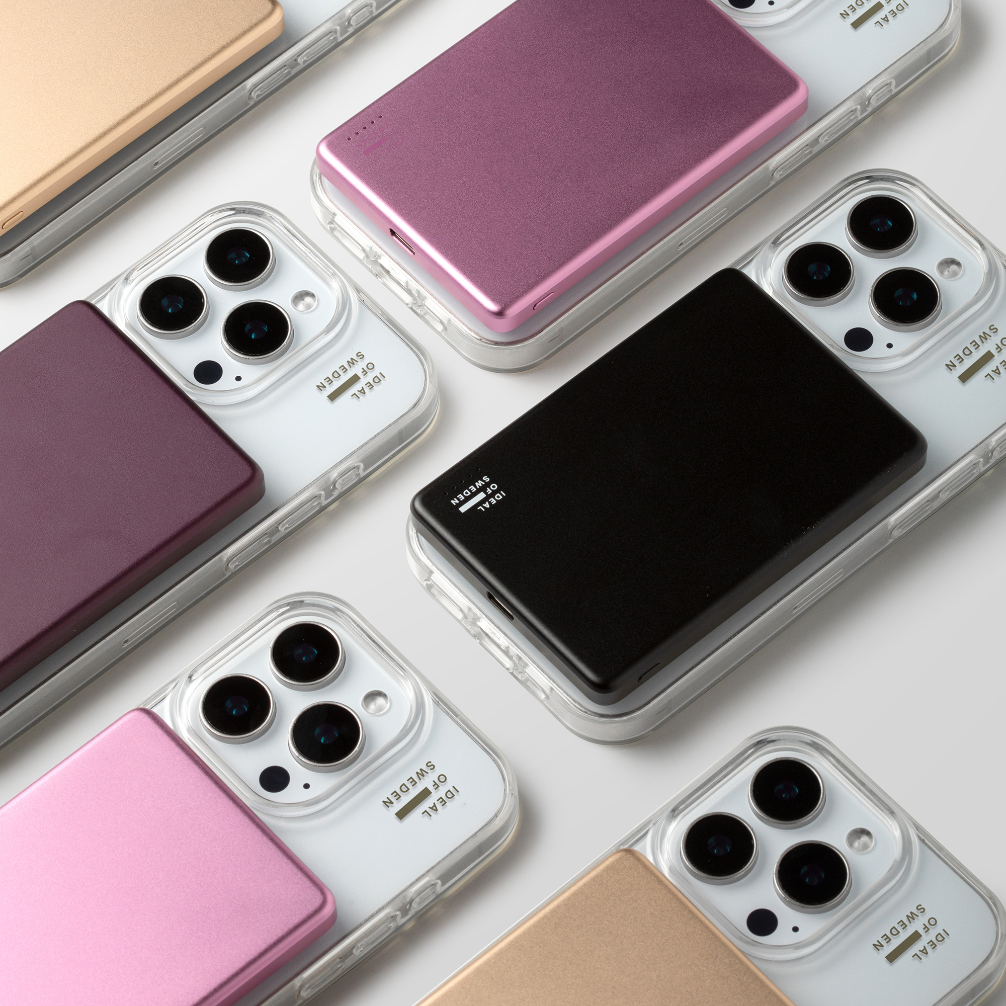 Plusieurs smartphones avec des coques transparentes et des portefeuilles magnétiques colorés sur fond blanc.