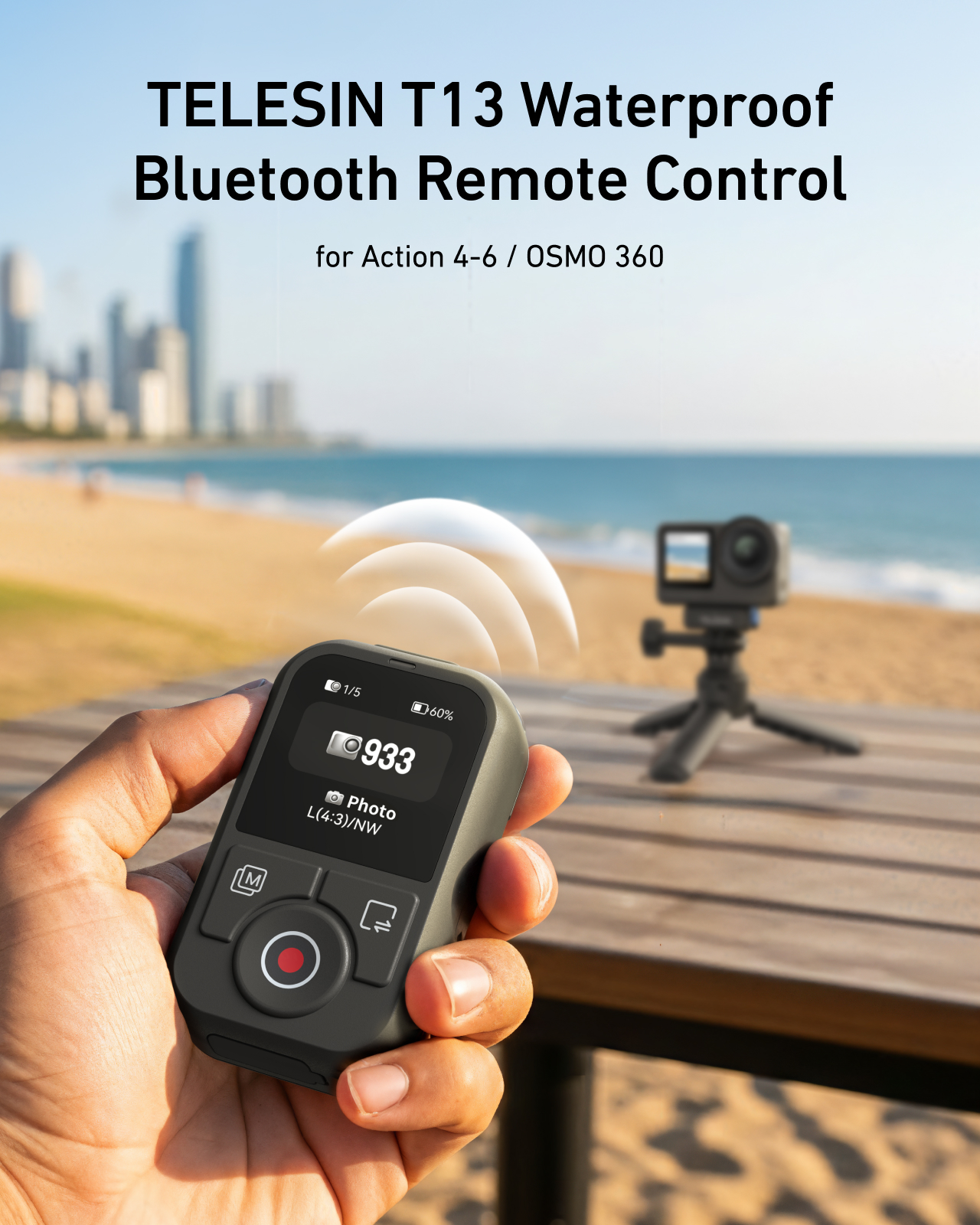 Hand houdt Telesin T13 Bluetooth afstandsbediening voor strand, met actiecamera op de achtergrond.