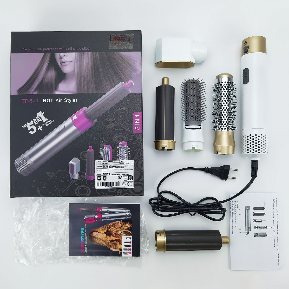 Ein 5-in-1-Heißluftstyler-Set mit Box, Styler, Zubehör, Handbuch und Netzkabel auf weißem Grund.