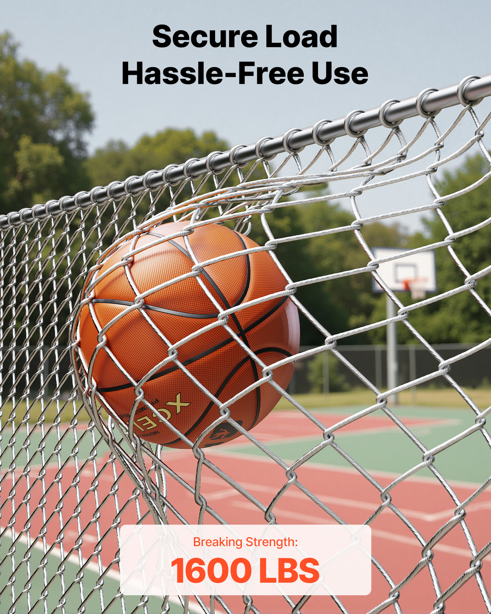 Un balón de baloncesto atrapado en una fuerte valla metálica plateada con una cancha de fondo.