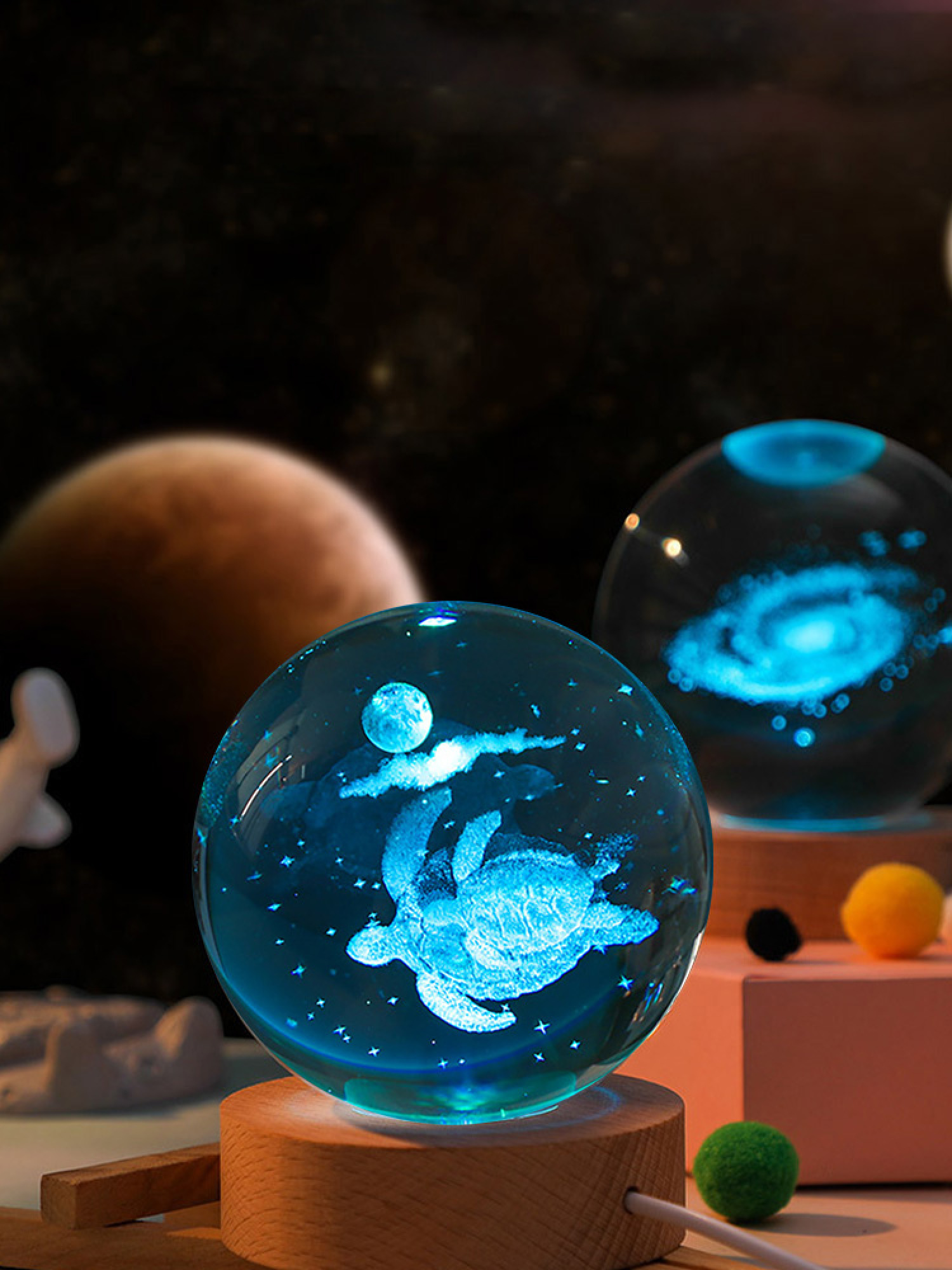 Eine Glaskugel mit einer blau leuchtenden Meeresschildkröte und Mond, auf einem Holzsockel vor einem Planeten.