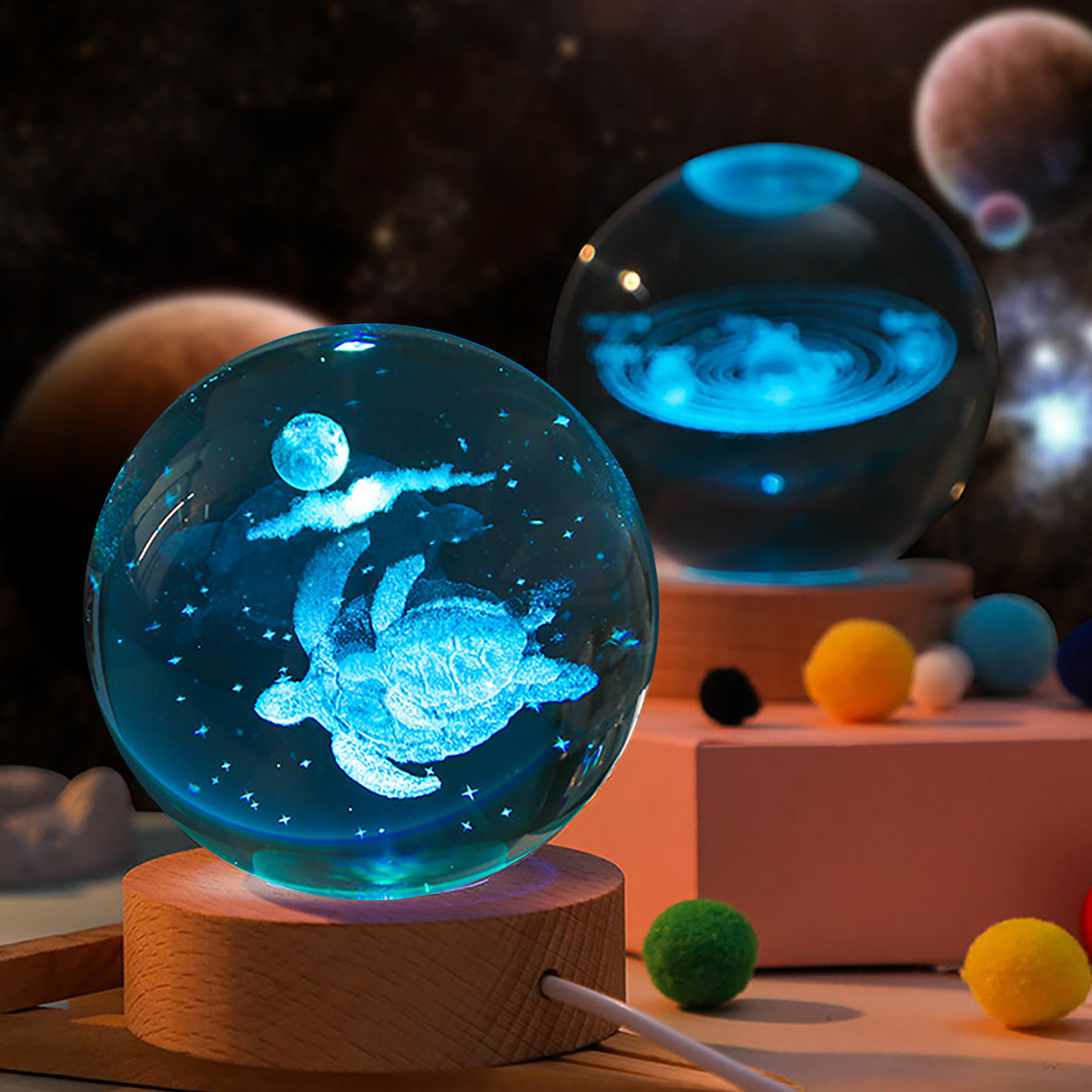 Zwei blau leuchtende Glaskugeln mit Weltraummotiven, eine zeigt eine Schildkröte, auf Holzsockeln vor galaktischem Hintergrund.