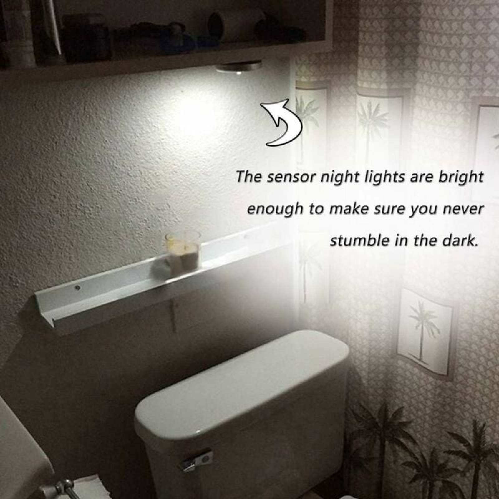 Ein Badezimmer mit weißer Toilette, Regal und einer hellen LED-Sensor-Nachtlampe an der Wand.