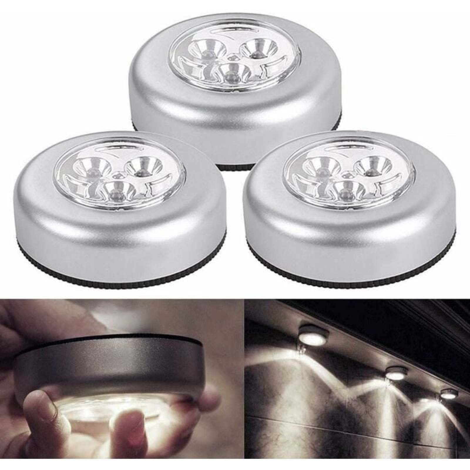 Drei runde silberne LED-Druckleuchten, eine wird gehalten, drei sind unter einem Schrank montiert.