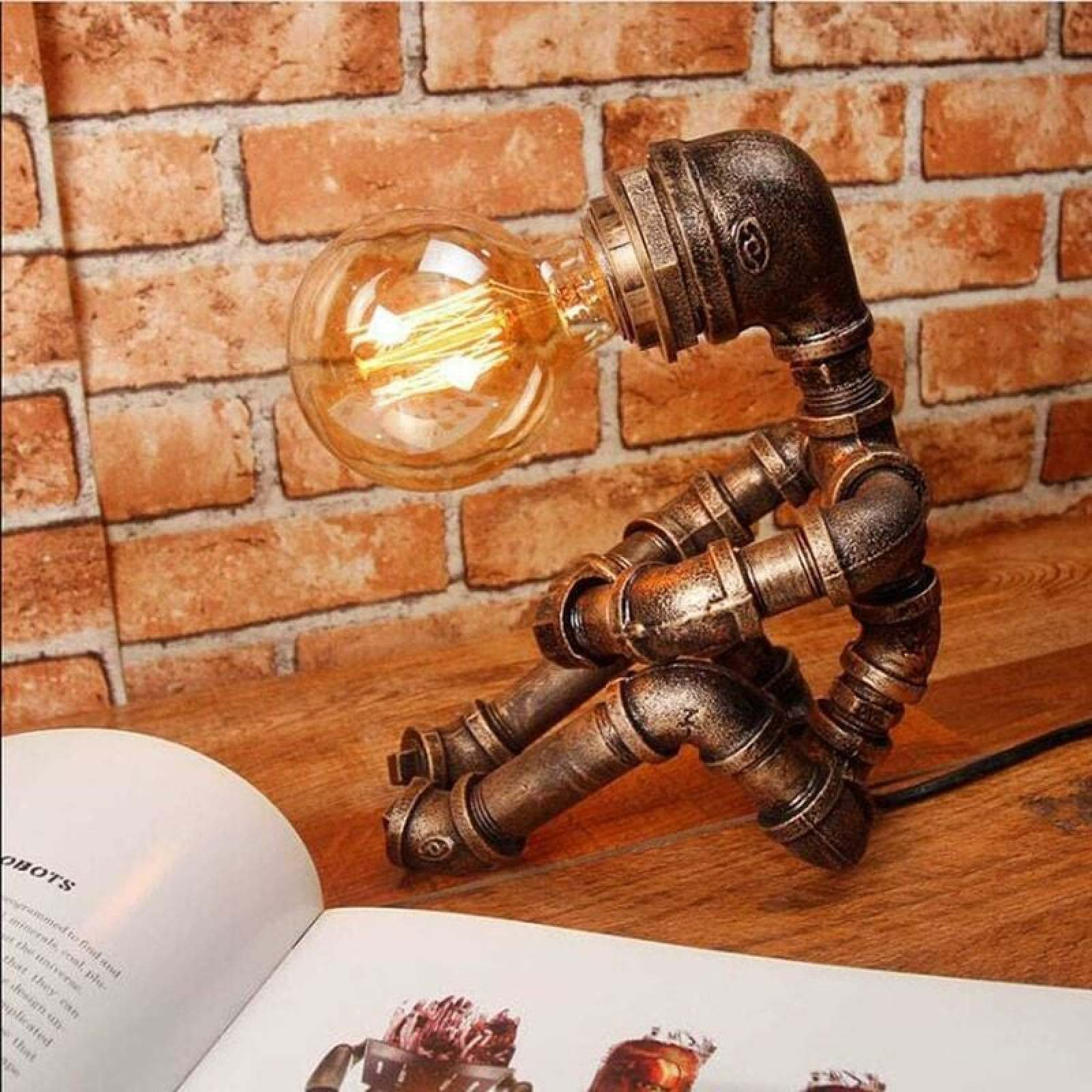 Eine Stehlampe aus Metallrohren im Industrie-Look sitzt vor einer Ziegelwand und beleuchtet ein offenes Buch.