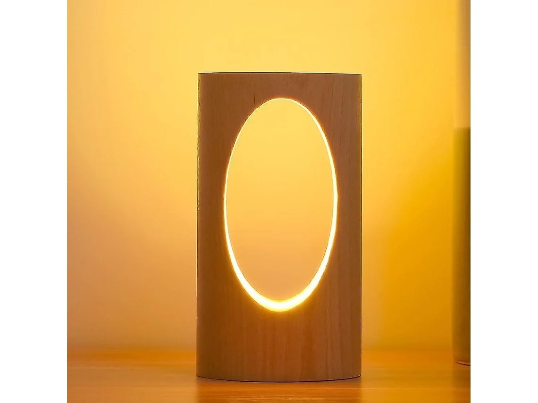 Eine zylindrische Holzlampe mit einem leuchtenden ovalen Ausschnitt, die warmes Licht auf eine Holzoberfläche wirft.