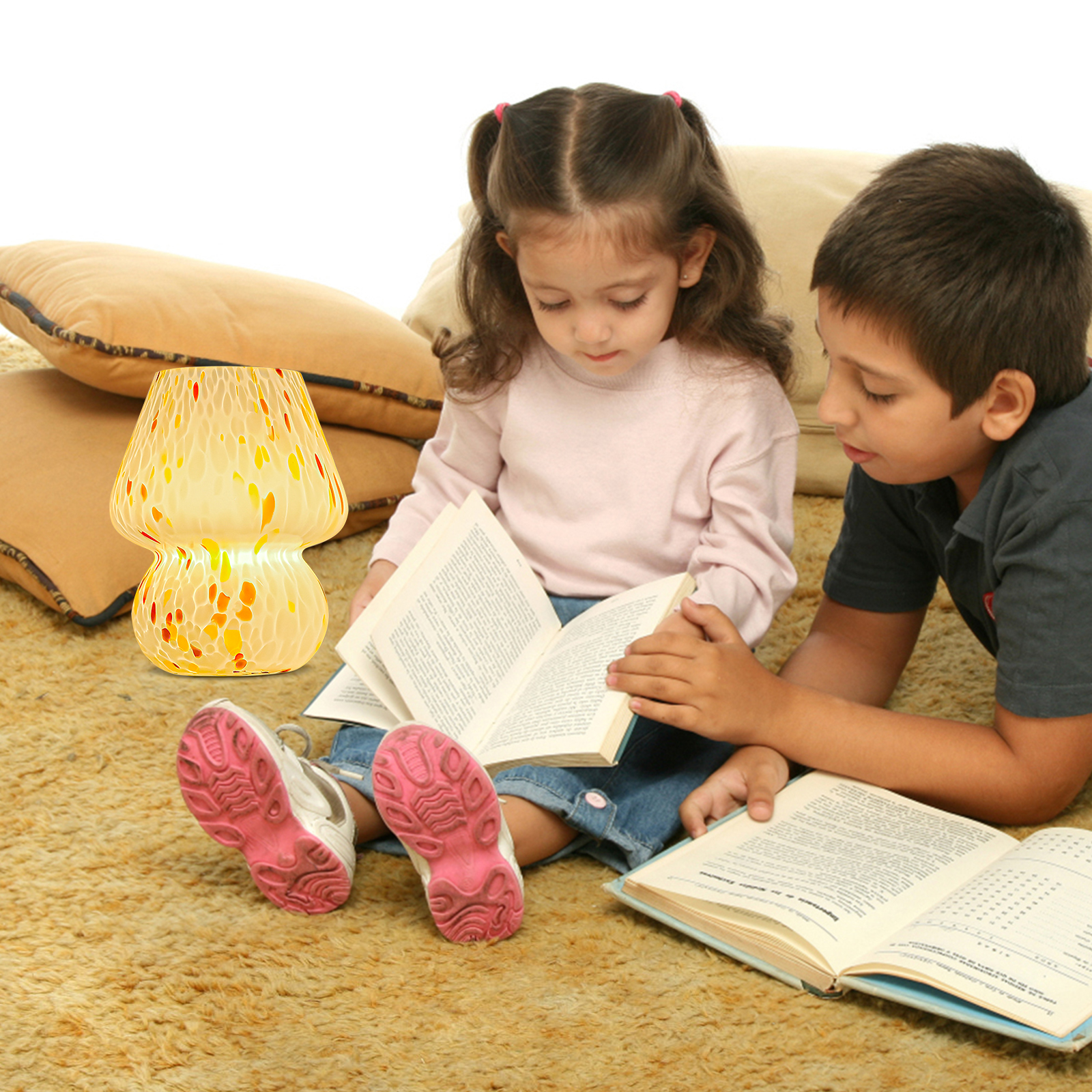 Ein junges Mädchen und ein Junge sitzen auf einem Teppich und lesen Bücher neben einer Lampe.