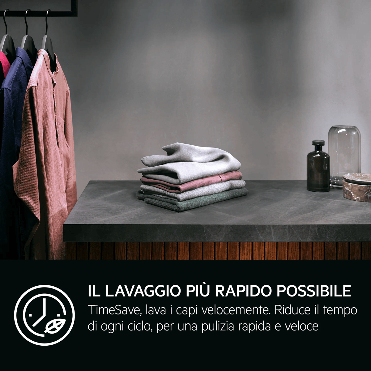 Du linge plié sur un comptoir sombre près de bouteilles, des vêtements suspendus à gauche et du texte italien en bas.