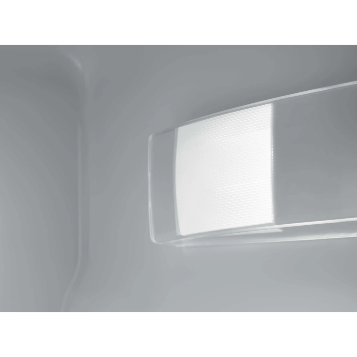 Interno illuminato di un elettrodomestico bianco, in primo piano.