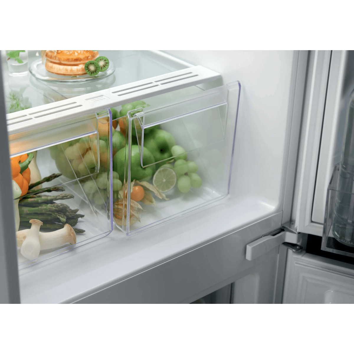 Un frigorifero bianco aperto con cassetti trasparenti pieni di verdure fresche e uva verde.