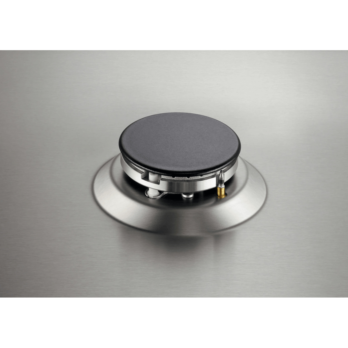 A stainless steel gas stove burner with a black cap, centered on a brushed metal cooktop surface.