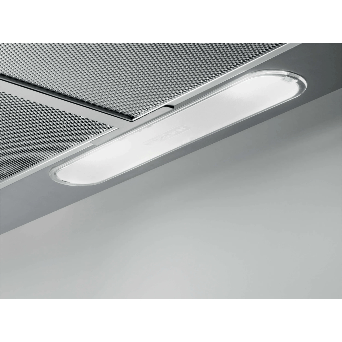 Primer plano de campana extractora de acero inoxidable con rejilla metálica y luz LED brillante.