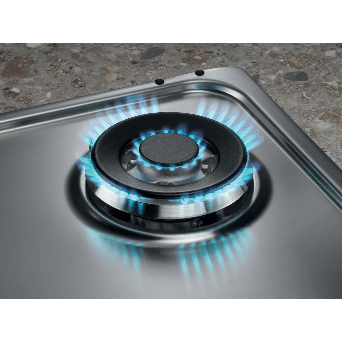 A blue gas flame burns on a stainless steel gas hob.