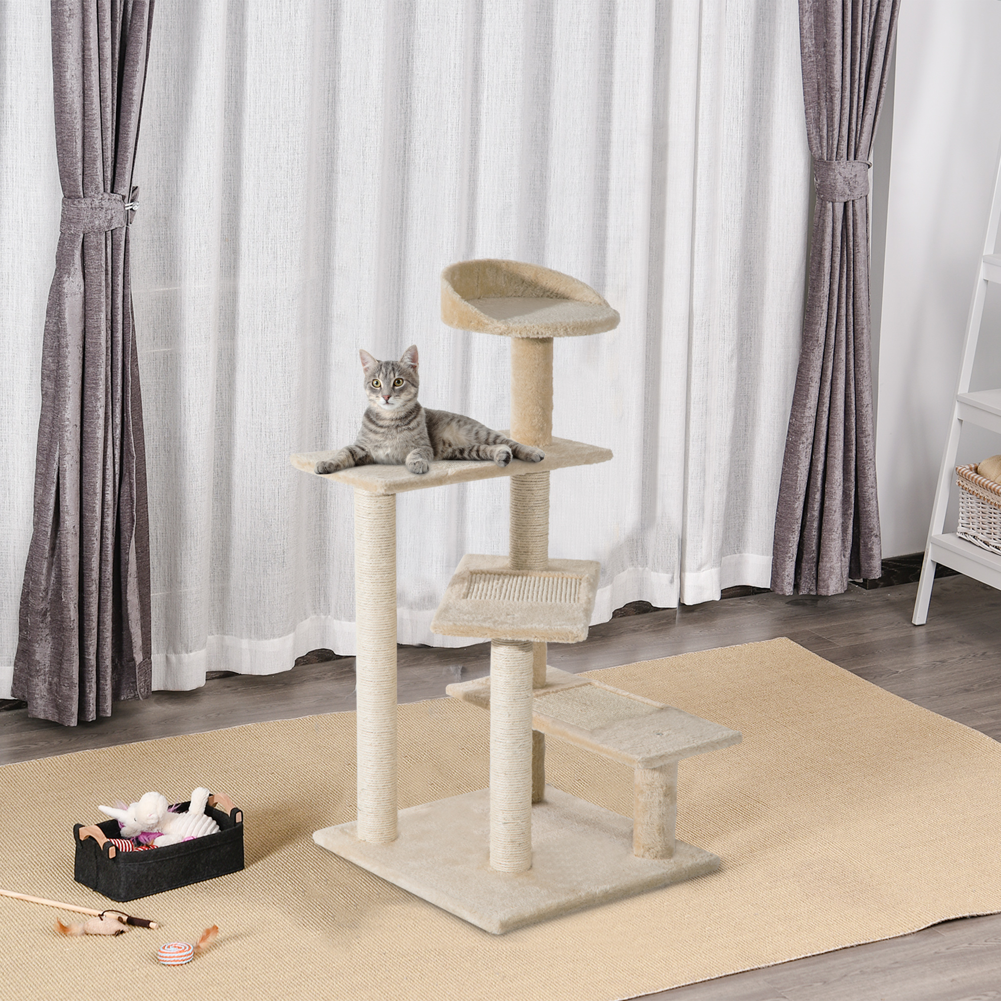 Un gatto tabby grigio riposa su un tiragraffi beige a più livelli davanti a tende chiare.