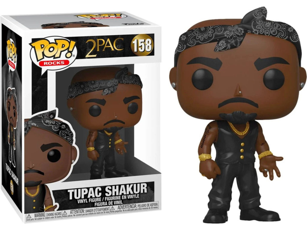 Eine Funko Pop Vinylfigur von 2Pac Shakur in schwarzem Outfit mit Bandana und Goldaccessoires neben ihrer Schachtel.