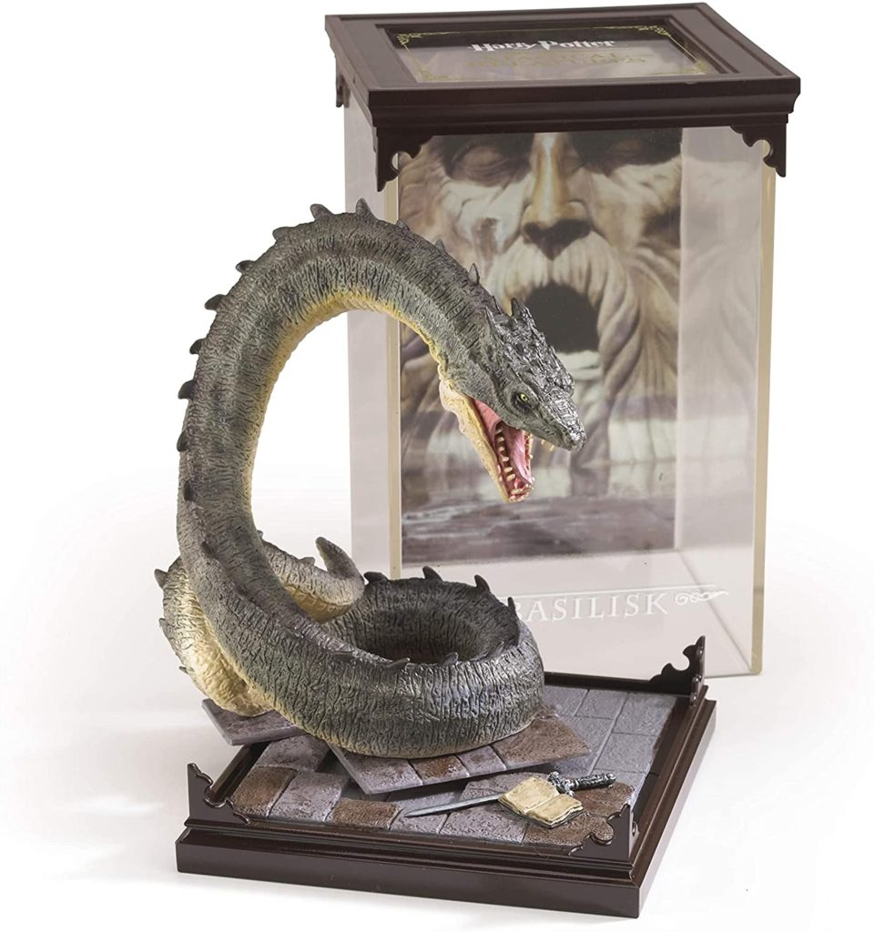 Una figura detallada de un basilisco con la boca abierta en un suelo de piedra, frente a una vitrina con la cara de Salazar Slytherin.