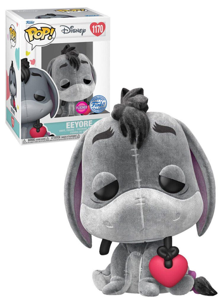 Eine beflockte Eeyore Funko Pop Figur mit einem roten Herzen, vor der Themenverpackung.
