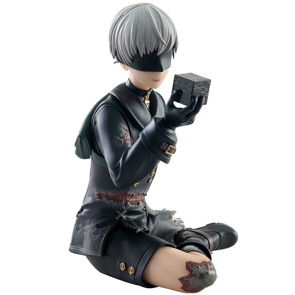 Una figura de 9S de Nier Automata con cabello blanco, ropa negra y una venda en los ojos, sosteniendo un cubo.