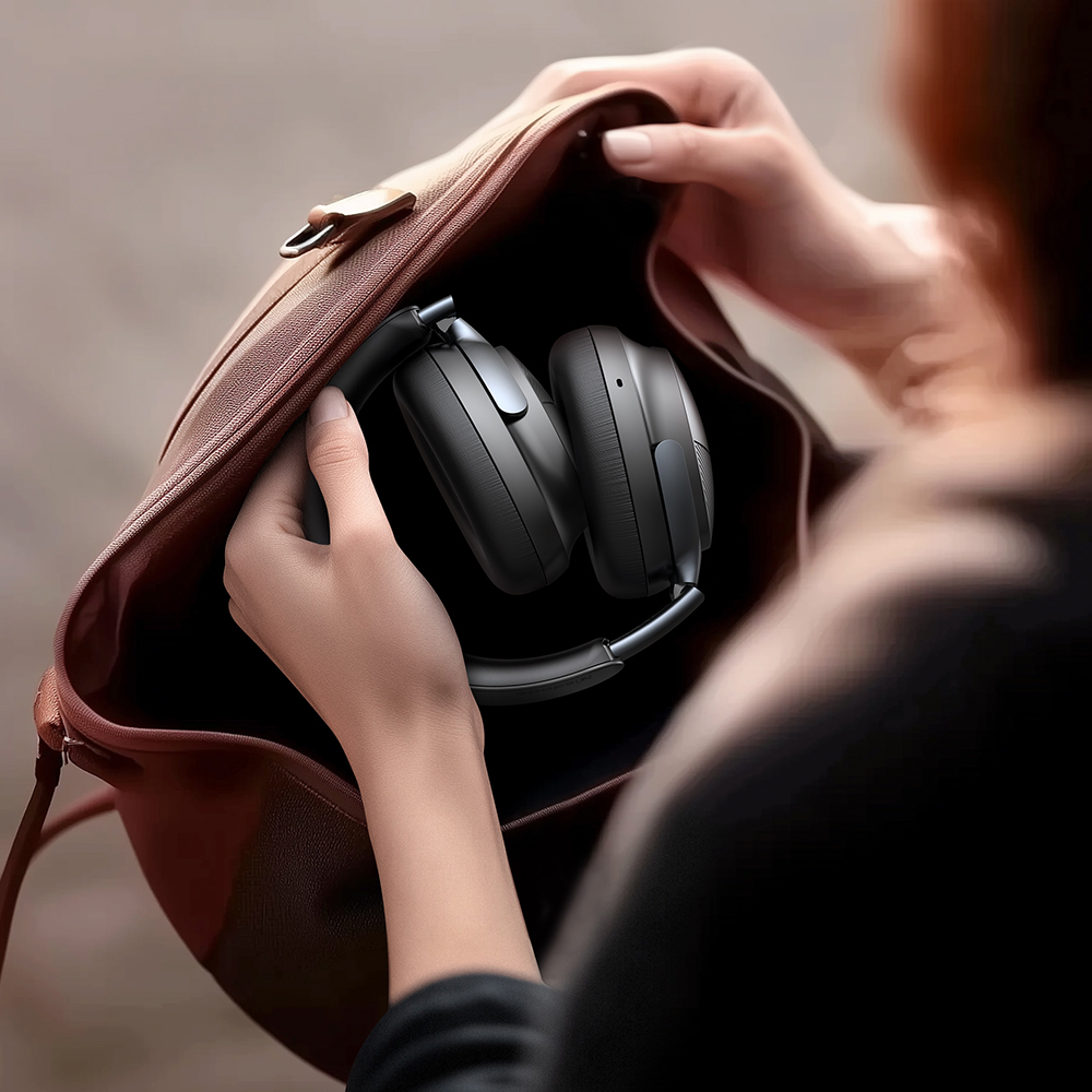 Una donna ripone delle cuffie nere over-ear in una borsa marrone.