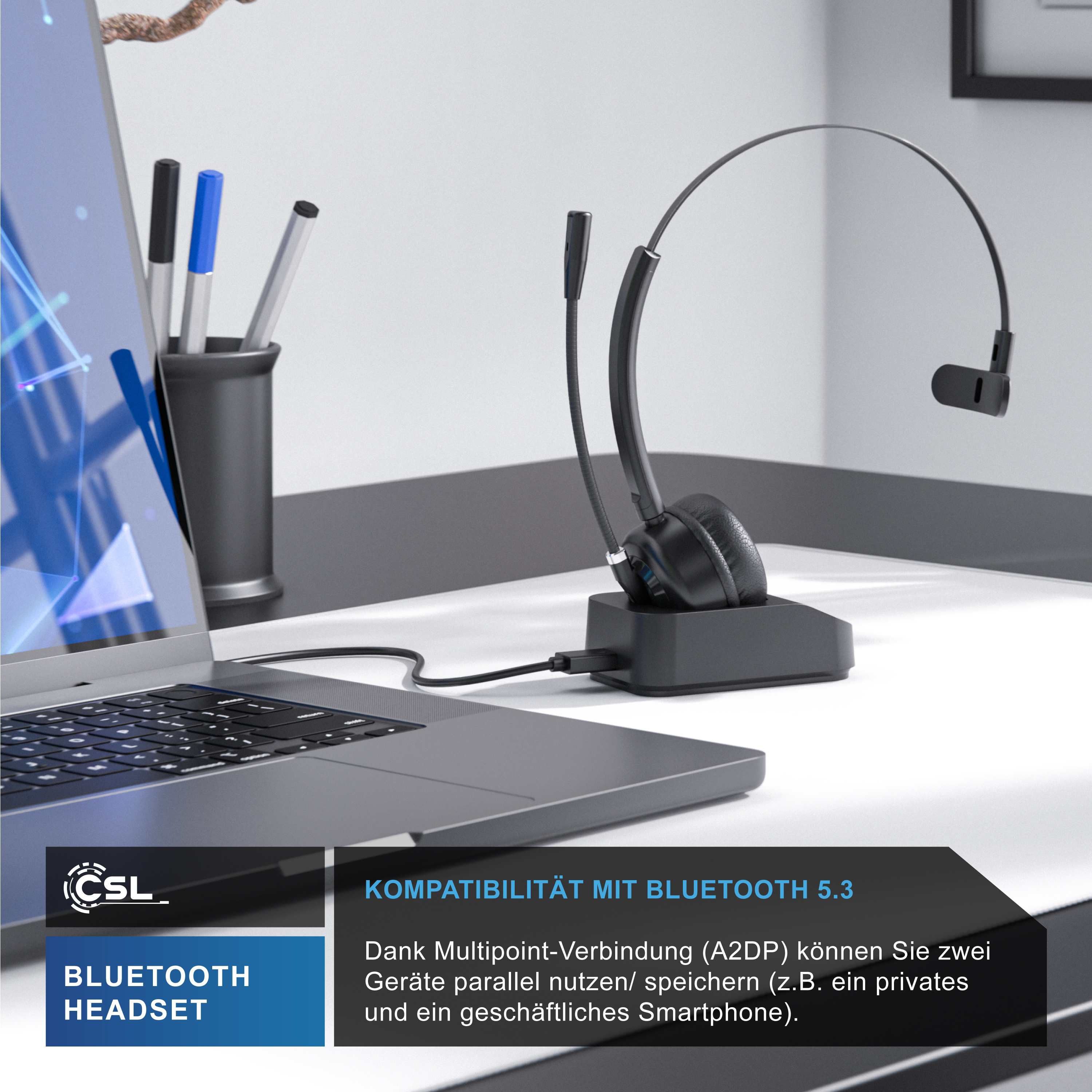 Ein schwarzes Bluetooth-Headset auf seiner Ladestation neben einem Laptop auf einem Schreibtisch.