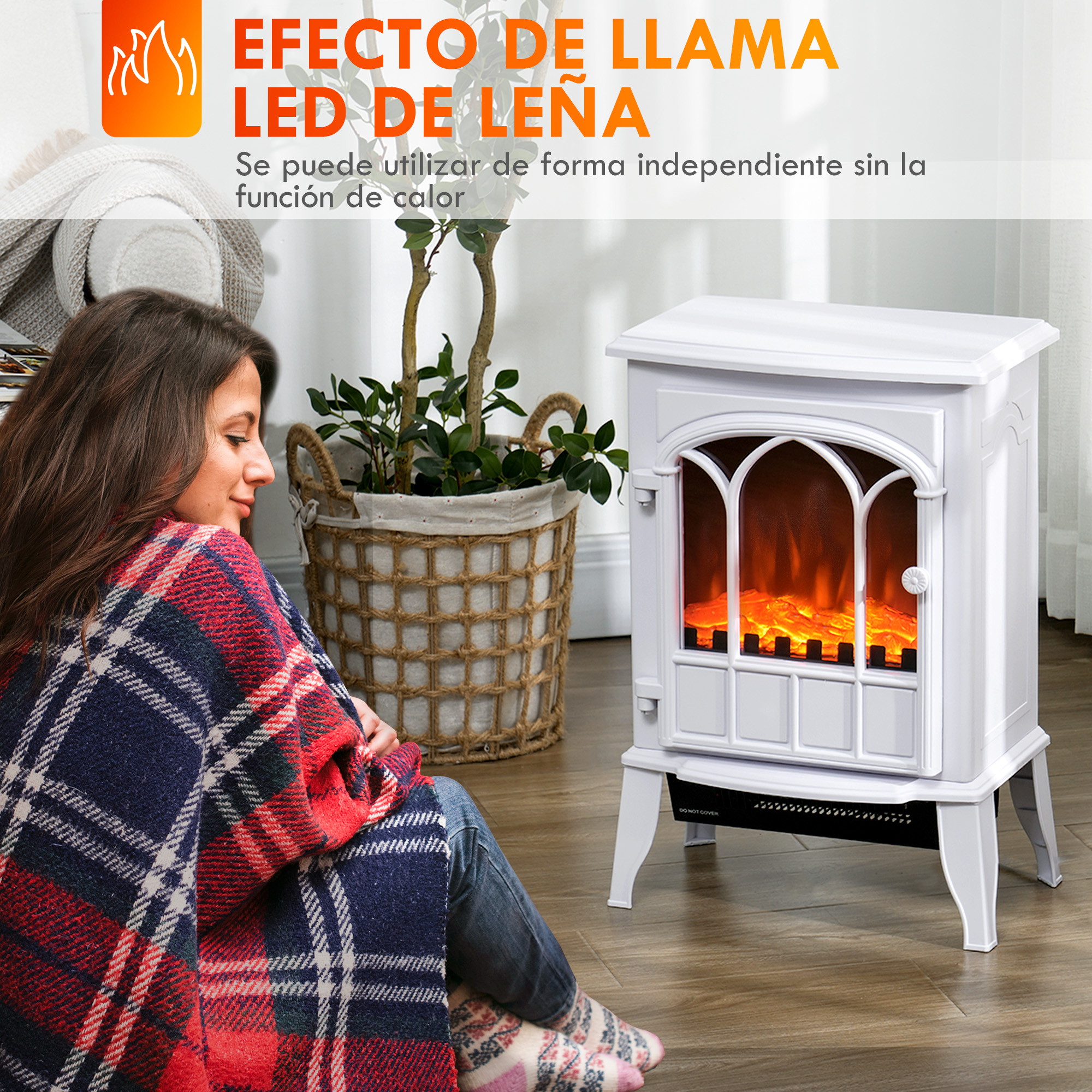 Una mujer envuelta en una manta de cuadros se sienta junto a una chimenea eléctrica blanca.