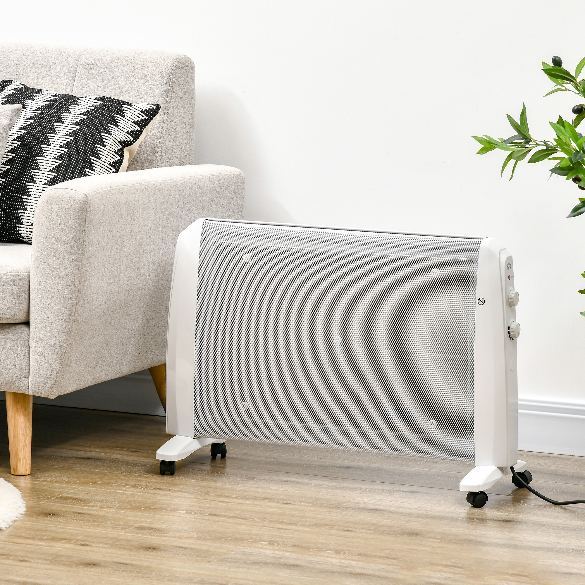 Un calefactor convector blanco con ruedas sobre suelo de madera junto a un sofá y una planta verde.