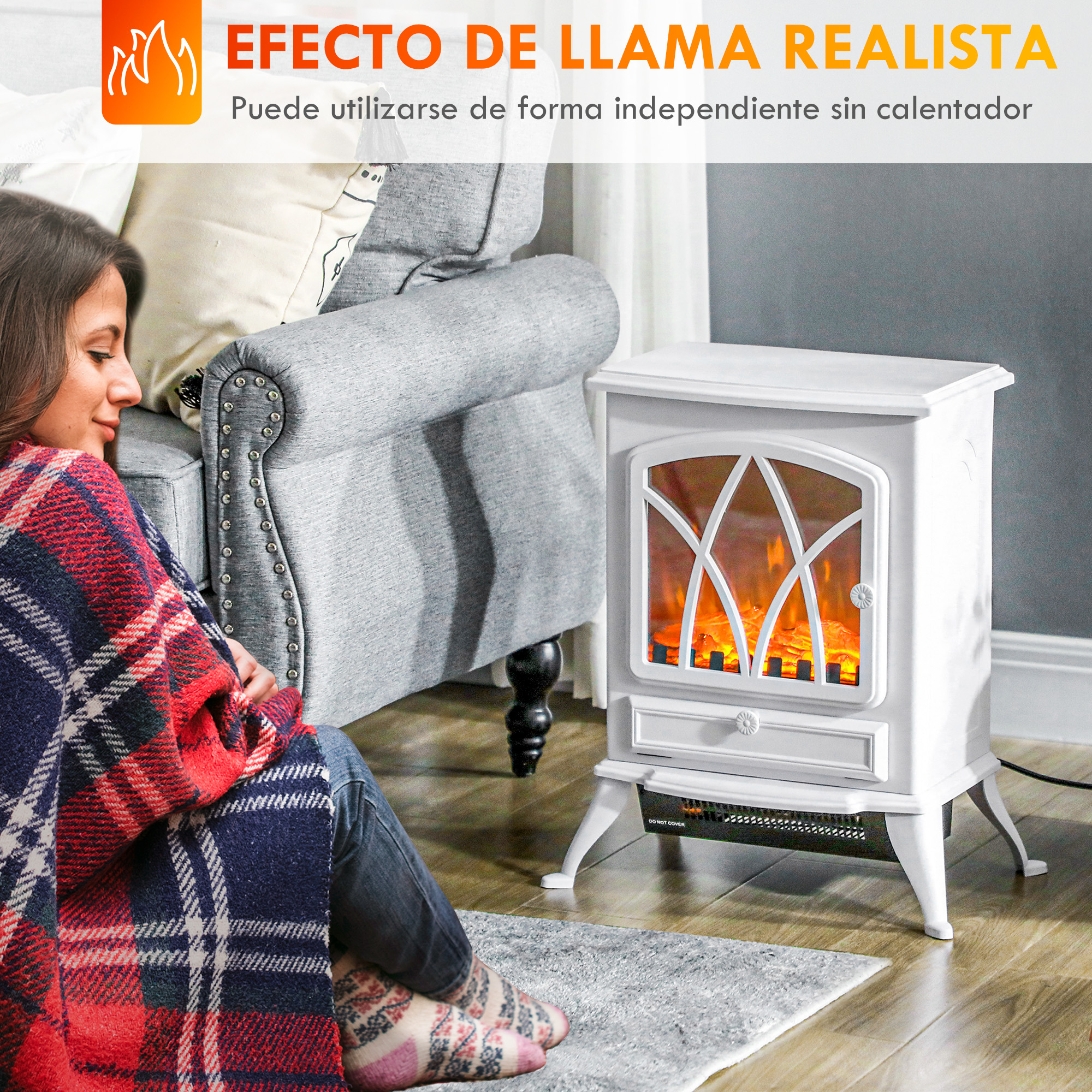 Una mujer envuelta en una manta se sienta junto a una chimenea eléctrica blanca con efecto de llama.