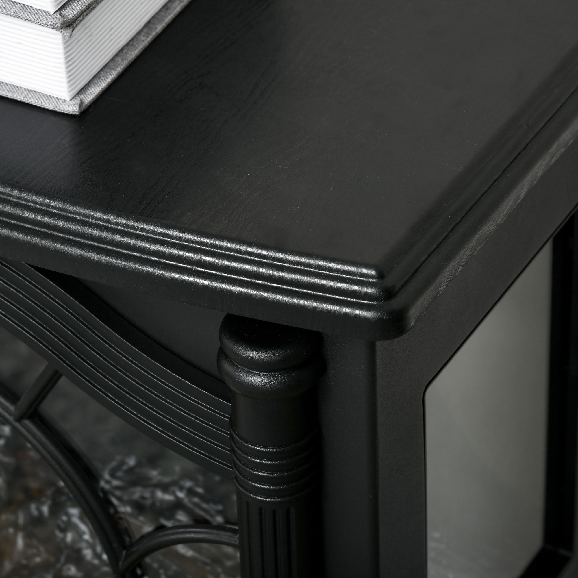 Primer plano de una mesa de madera negra con un libro gris en la esquina y una pata ornamentada.