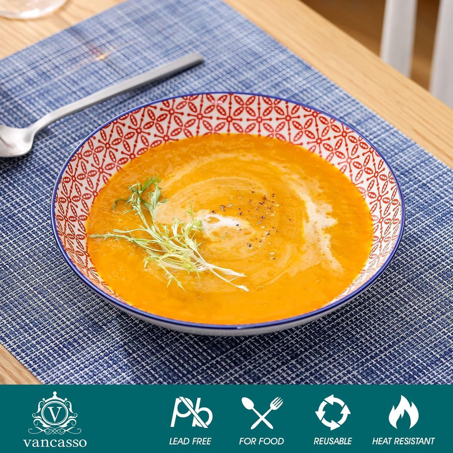 Una ciotola fantasia con zuppa di zucca ed erbe aromatiche su una tovaglietta blu.