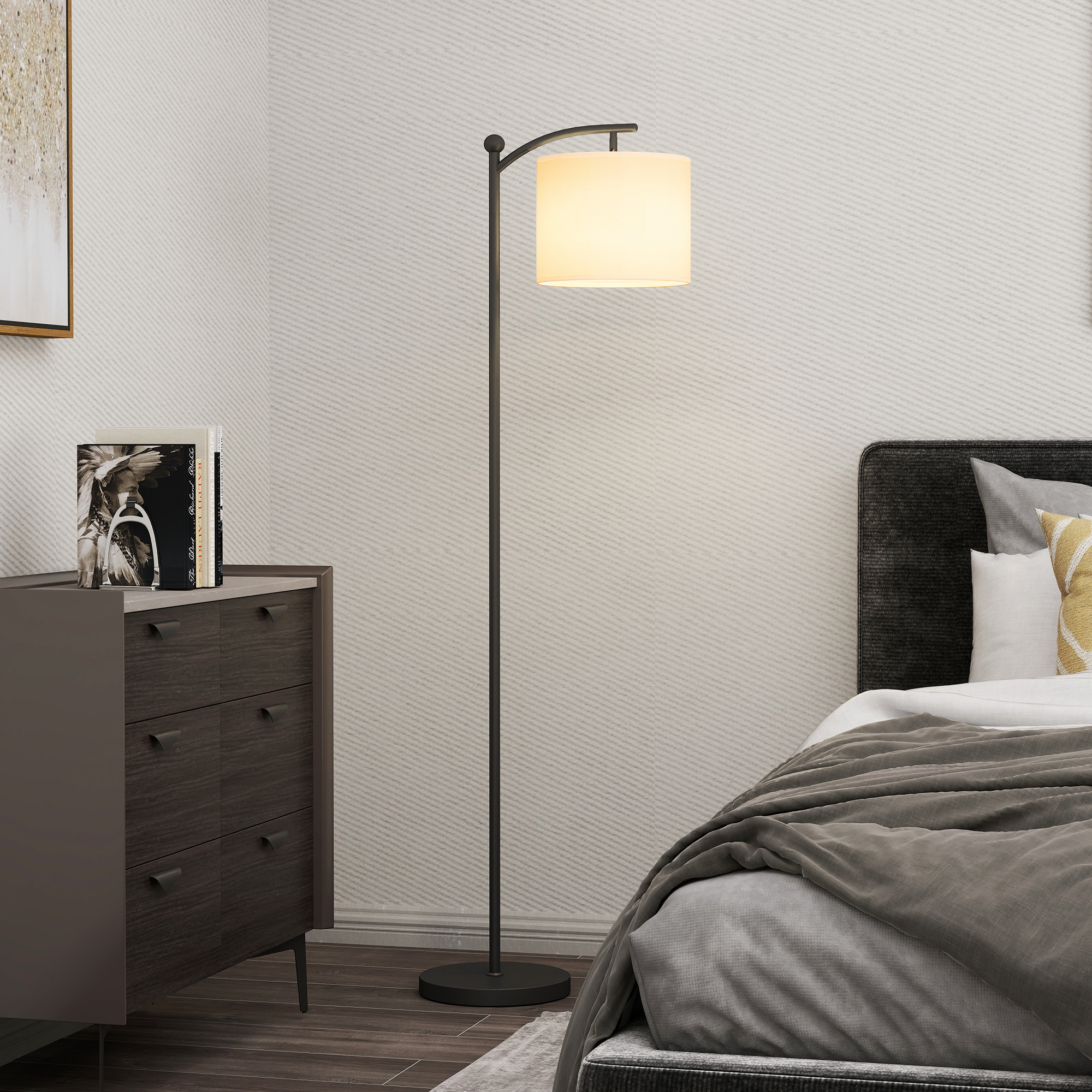Moderna lampada da terra con paralume bianco tra cassettiera scura e letto.