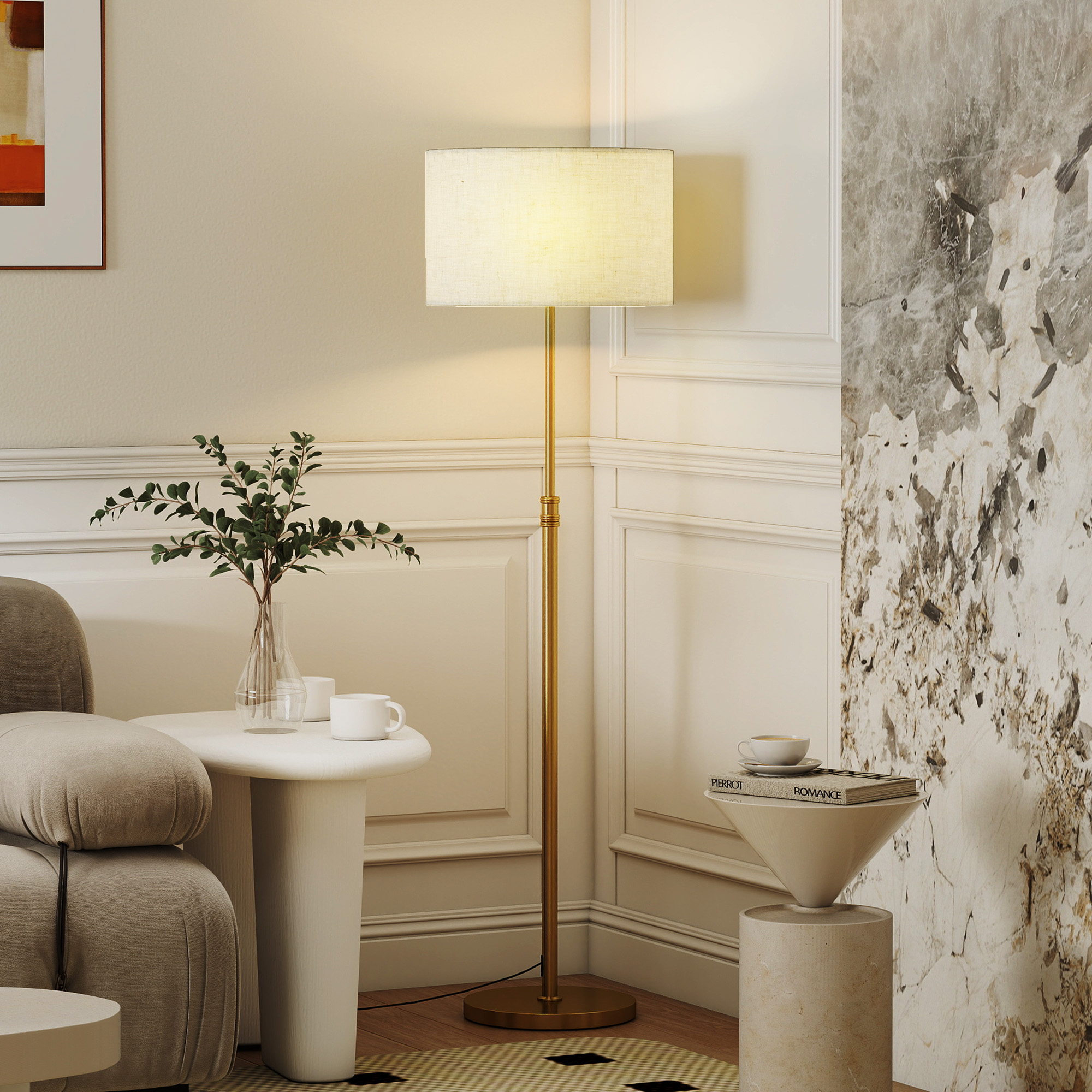 Una lampada da terra dorata con paralume beige si trova in un angolo accanto a due piccoli tavolini e a una pianta.