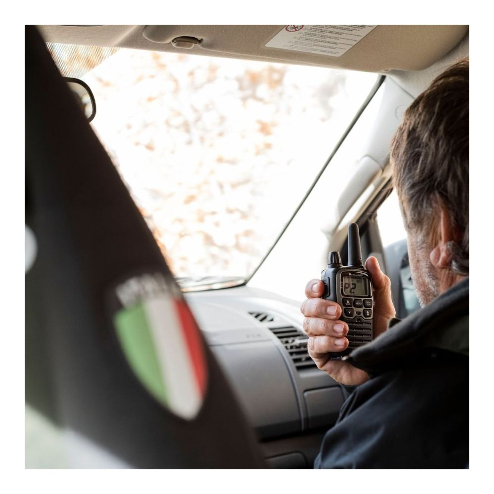 Ein Mann im Auto hält ein Handfunkgerät.