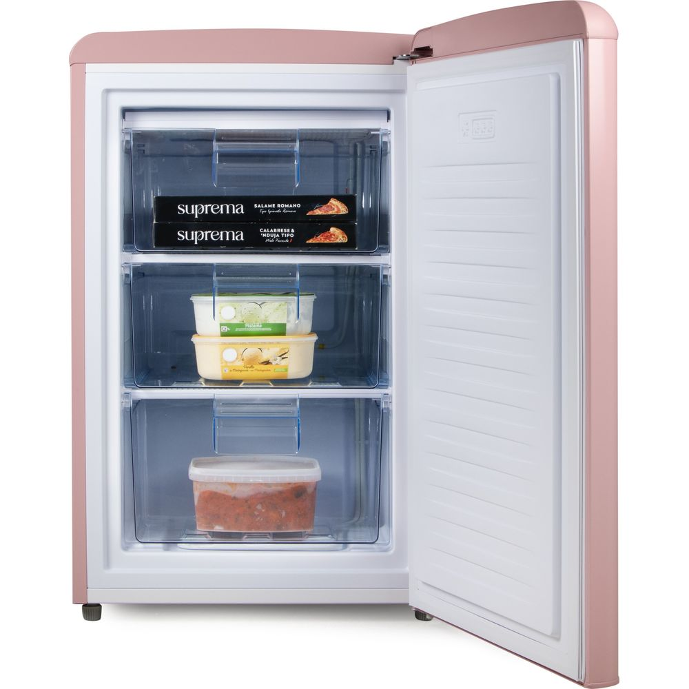 Congélateur rétro rose pastel ouvert avec tiroirs transparents contenant des boîtes de pizza, des bacs et un plat.