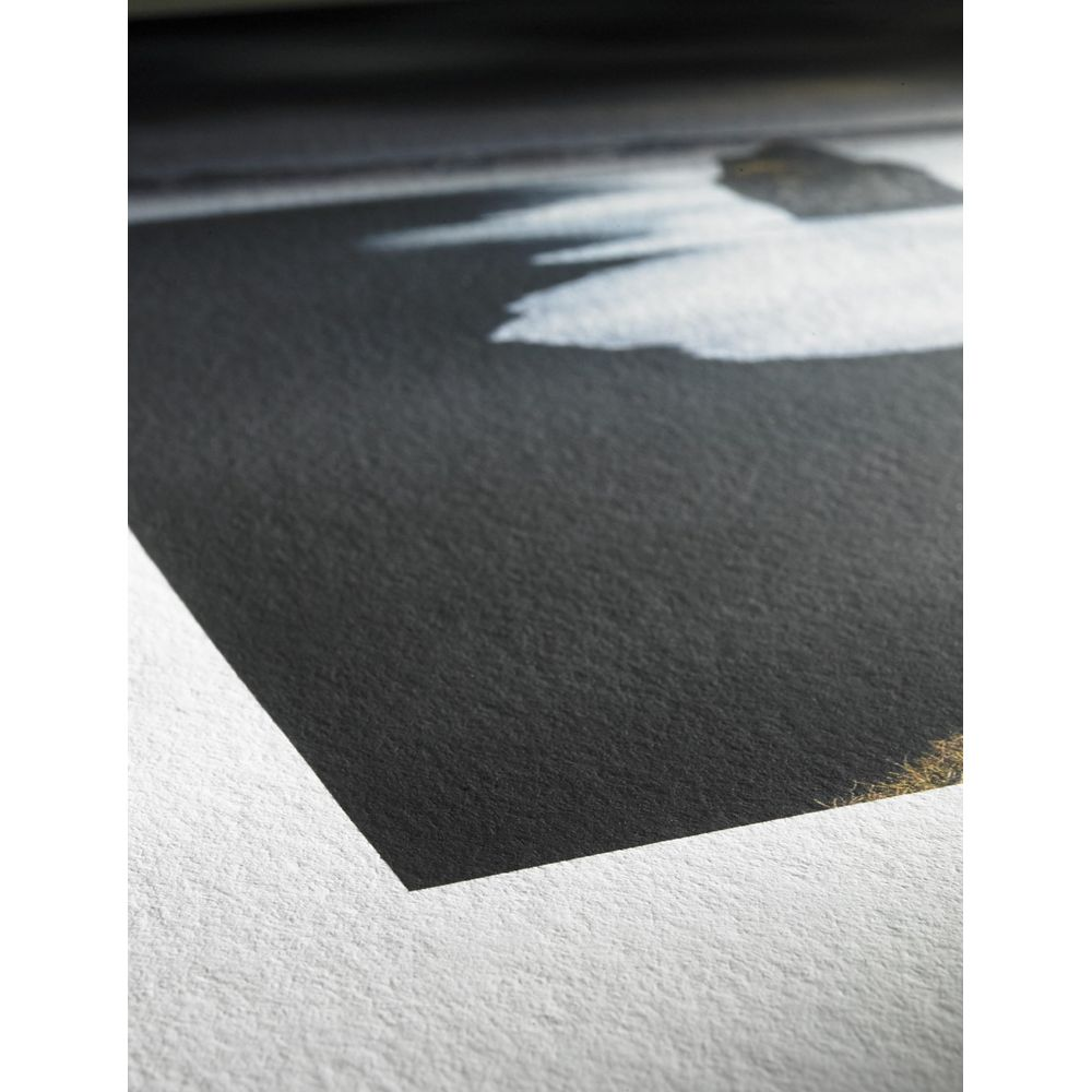 Nahaufnahme eines strukturierten Kunstdrucks auf schwerem weißen Papier mit dunkler Landschaft und weißem Schaum.