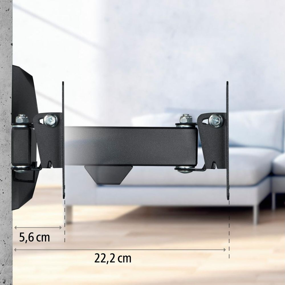 Schwarze TV-Wandhalterung mit Maßangaben von 5,6 cm und 22,2 cm vor einem verschwommenen Raum.