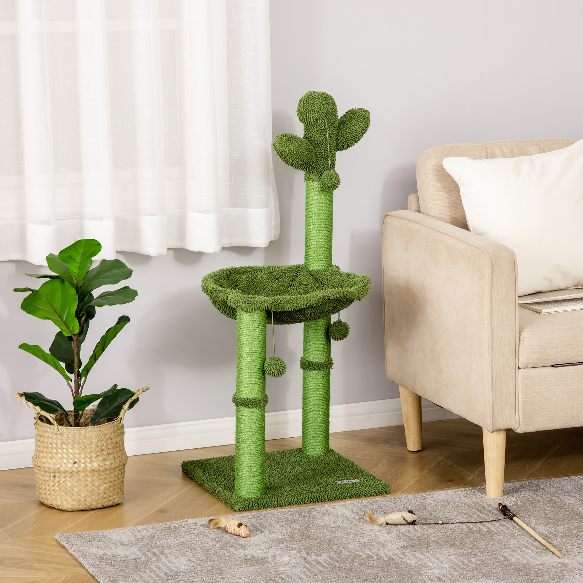 Un tiragraffi verde a forma di cactus si trova vicino a un divano beige e a una pianta.